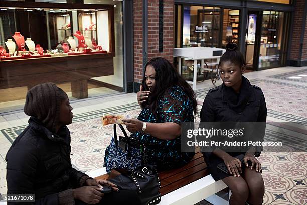 Nigerian model agency owner Joan Okorodudu hands out cash to her models Bumni Ademokoya and Favour Lucky, a 15-year old Nigerian model, at a shopping...