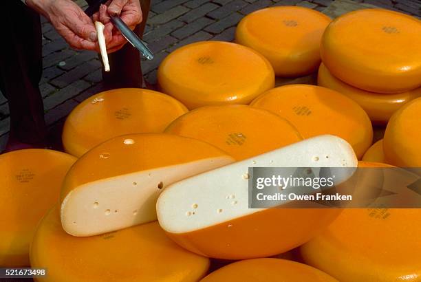 cheese buyer sampling cheese - edamer stock-fotos und bilder