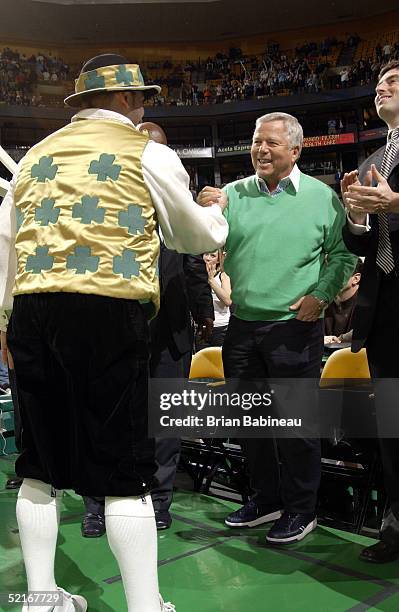 Owner Robert Kraft of the New England Patriots shakes hands with mascot Lucky of the Boston Celtics during the first quarter against the Los Angeles...