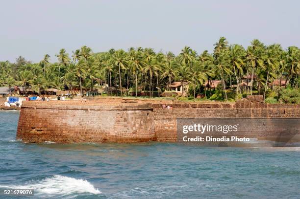 lower fort aguada and dense coconut palms at sinquerim beach, goa, india - fortress stock pictures, royalty-free photos & images