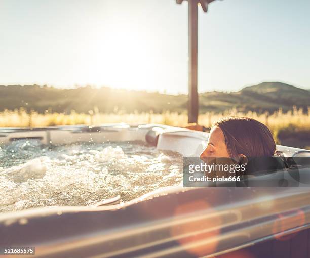 femme dans un bain à remous jacuzzi - bain à remous photos et images de collection