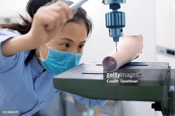 worker is using a drilling machine to process a prosthetic - prosthetic limb stock pictures, royalty-free photos & images