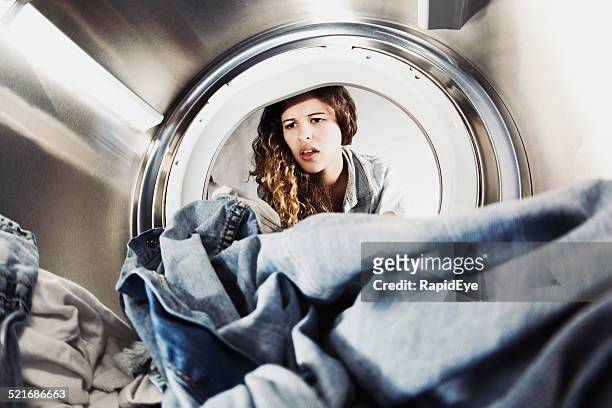 pretty woman pulling face at laundry in drier - dirty women pics stock pictures, royalty-free photos & images