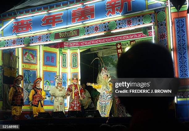 Man watches traditional Chinese Opera performed on stage at Wat Traimit in Bangkok's Chinatown, late 09 February 2005. Thousands of people flocked to...