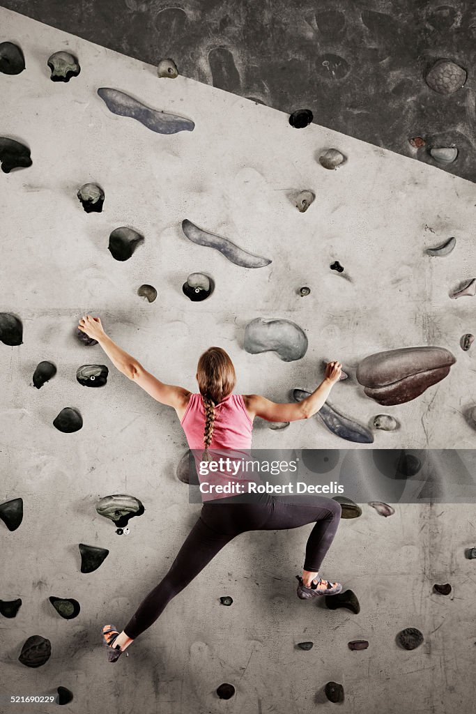 Female climber scaling indoor wall