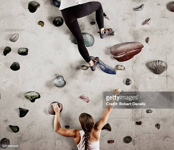 two female climbers on climbing wall - kletterwand kletterausrüstung stock-fotos und bilder
