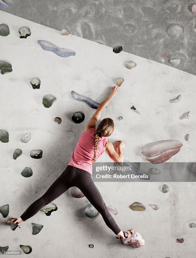 Female climber reaching for hold on indoor wall