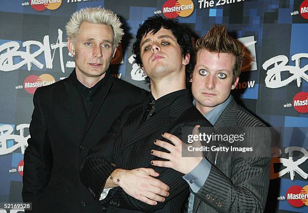 Green Day band members Tre Cool, Billie Joe Armstrong and Mike Dirnt pose in the press room during the 25th Anniversary BRIT Awards 2005 at Earl's...