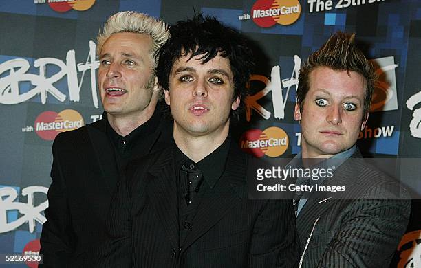 Green Day band members Tre Cool, Billie Joe Armstrong and Mike Dirnt pose in the press room during the 25th Anniversary BRIT Awards 2005 at Earl's...