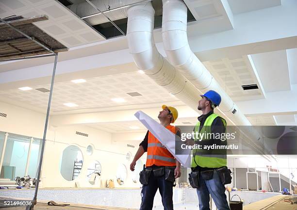 bau arbeiter lesen pläne liegen vor - baustelle stock-fotos und bilder