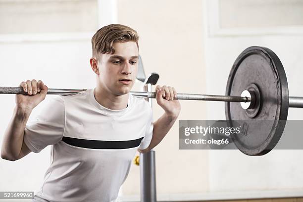 youth engaged in sports exercises with a barbell. - boy workout in gym stockfoto's en -beelden