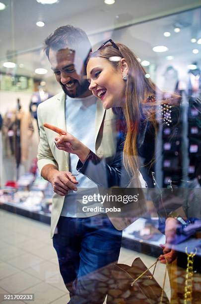 young  happy couple window shopping at a mall - couple shopping in shopping mall stockfoto's en -beelden