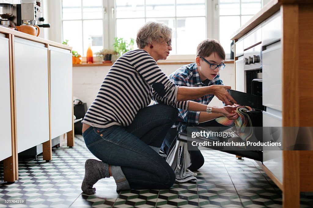 Mature Mother teaching her teenage Son how to bake