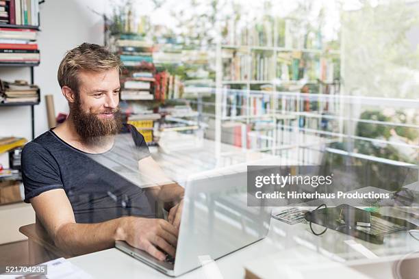 young bearded man working at home office - effet miroir homme photos et images de collection