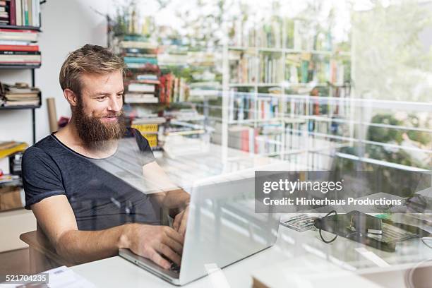 young bearded man working at home office - working from home happy stock pictures, royalty-free photos & images