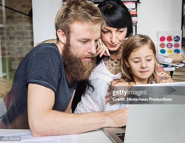 young family browsing internet with laptop - leanincollection father fotografías e imágenes de stock