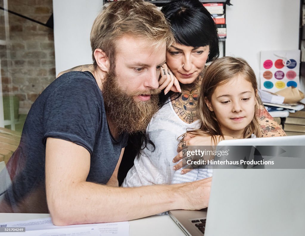 Young Family Browsing Internet With Laptop