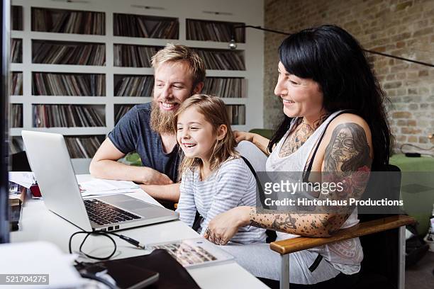 young family browsing internet with laptop - young man laptop couch photos et images de collection