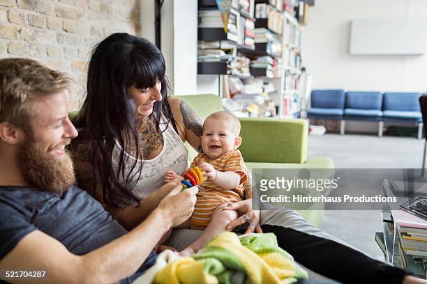 young couple relaxing with their new born baby - two parents stock-fotos und bilder