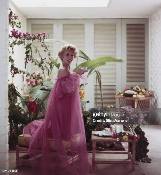 And film actress Eva Gabor takes a coffee in an unfinished bedroom in Bay Roc Hotel, Montego, Jamaica, 1950.