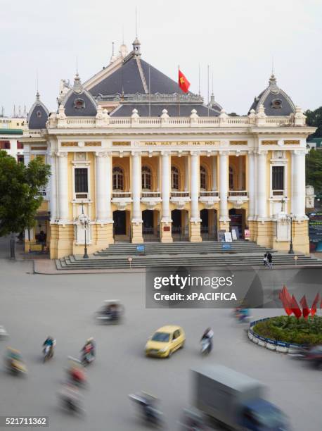 traffic buzzing by the hanoi opera house - hanoi opera stock pictures, royalty-free photos & images