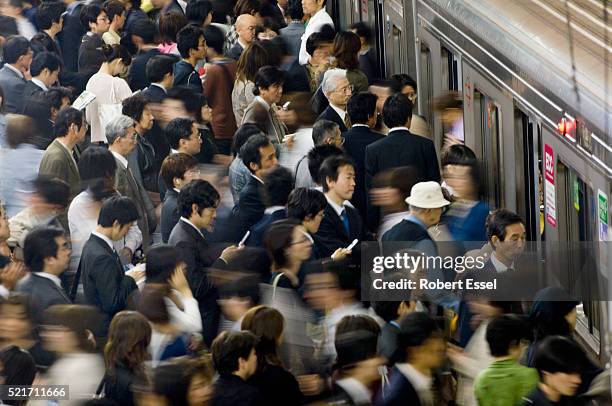 commuters rushing onto train at umeda subway station in osaka - crowded train stock pictures, royalty-free photos & images