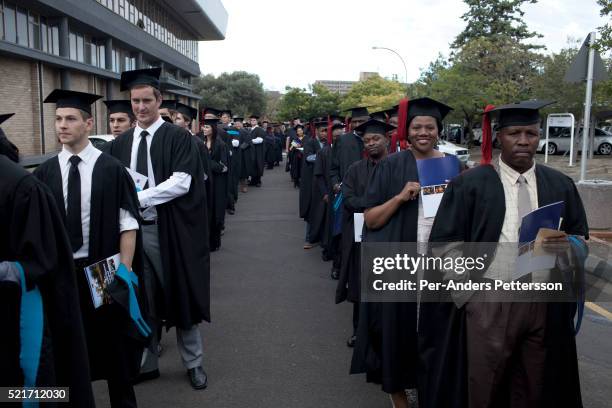 Students line up to attend their graduation ceremony at the University of the Free State in Bloemfontein, South Africa. Races are mixing more but...