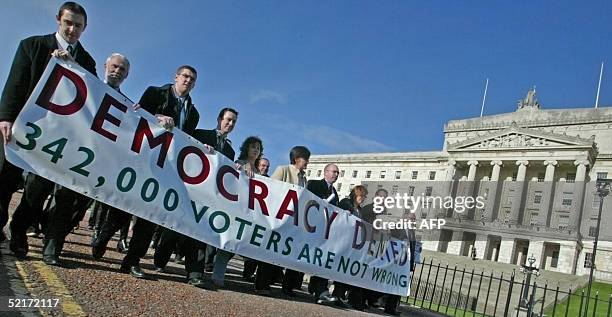 Sinn Fein assembly members protest outside Stormont 10 February 2005 after the IMC report was released in Belfast. The IMC has published a report...