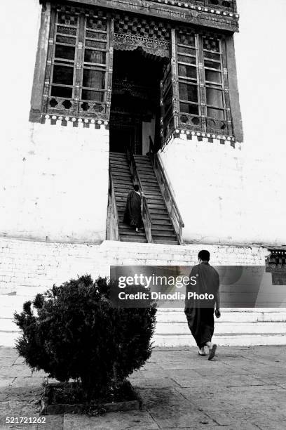 monks climbing stairs in buddhist monastery, thimphu, bhutan, 1989 - bhutan monk stock pictures, royalty-free photos & images