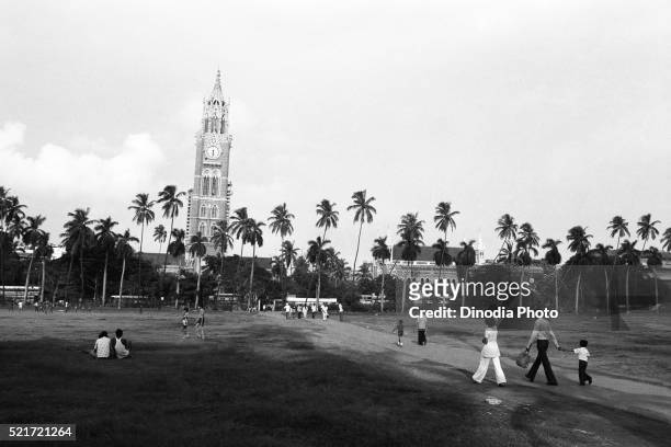 family crossing oval maidan to rajabhai tower, mumbai, maharashtra, india, asia, 1979 - city 70's photos et images de collection