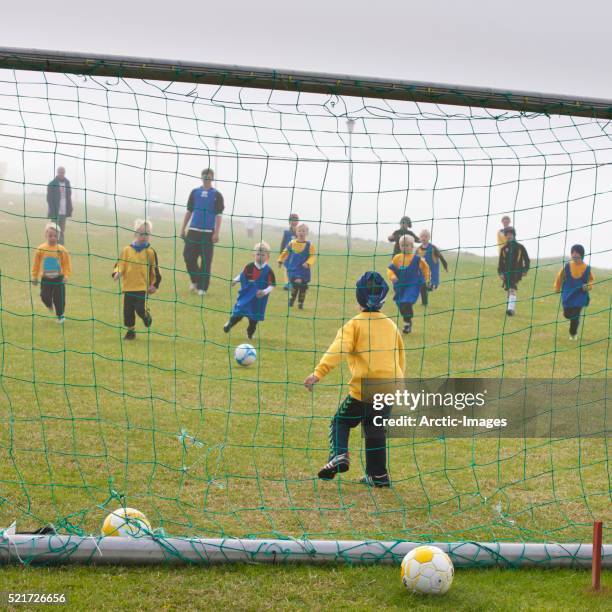 young children playing football aka soccer, iceland - akranes bildbanksfoton och bilder