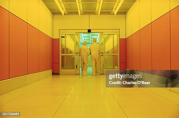 high tech workers entering a clean room - macacão de limpeza imagens e fotografias de stock