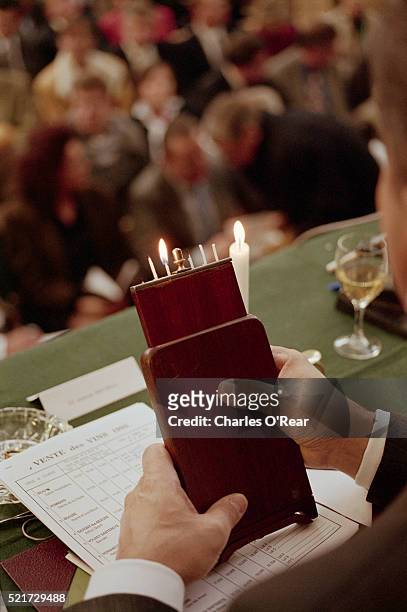 auctioneer lighting candles at wine auction - wine auction stock pictures, royalty-free photos & images