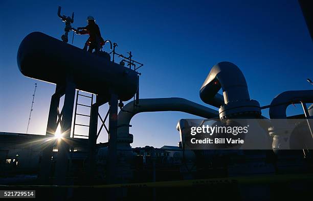 worker checking gauges on natural gas tank - aardgas stockfoto's en -beelden