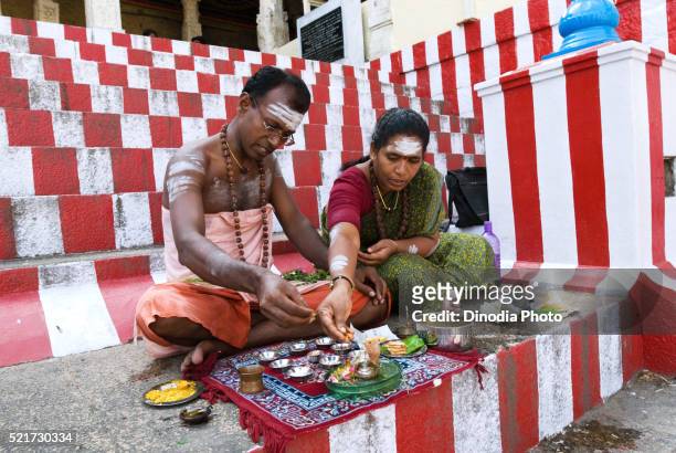 couple performing shiva pooja sitting on steps, madurai, tamil nadu, india august- - sitting shiva stock pictures, royalty-free photos & images