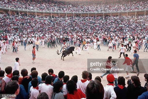crowd encircling bull during san fermin festival - encierros de toros fotografías e imágenes de stock