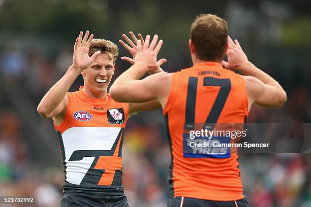 Lachie Whitfield of the Giants congratulates team mate Steve Johnson of the Giants after kicking a goal during the round four AFL match between the...