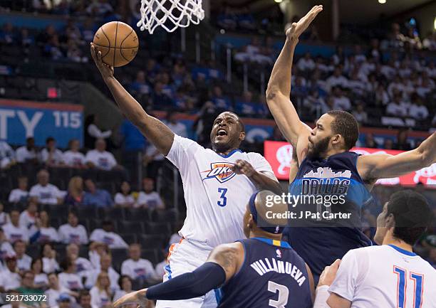 Dion Waiters of the Oklahoma City Thunder drives past JaVale McGee of the Dallas Mavericks for two points during the second half of Game One of the...