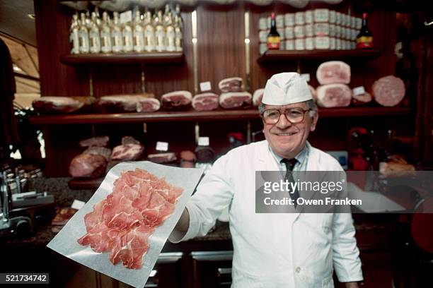 man holding paper thin slices of prosciutto - butcher stock pictures, royalty-free photos & images