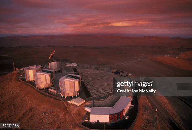 The sun sets on the Very Large Telescope , which consists of these four squared-off domes that stand on the top of the levelled mountain of Cerro...