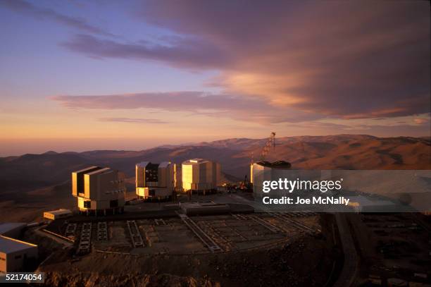 The sun sets on the Very Large Telescope , which consists of these four squared-off domes that stand on the top of the levelled mountain of Cerro...