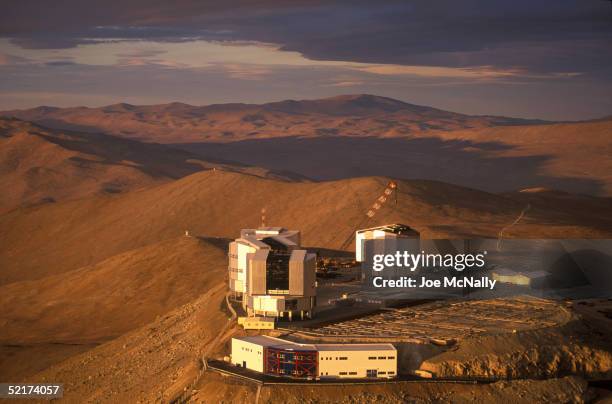 The sun sets on the Very Large Telescope , which consists of these four squared-off domes that stand on the top of the levelled mountain of Cerro...