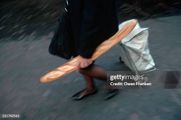 woman carrying a baguette - baguette de pain photos et images de collection