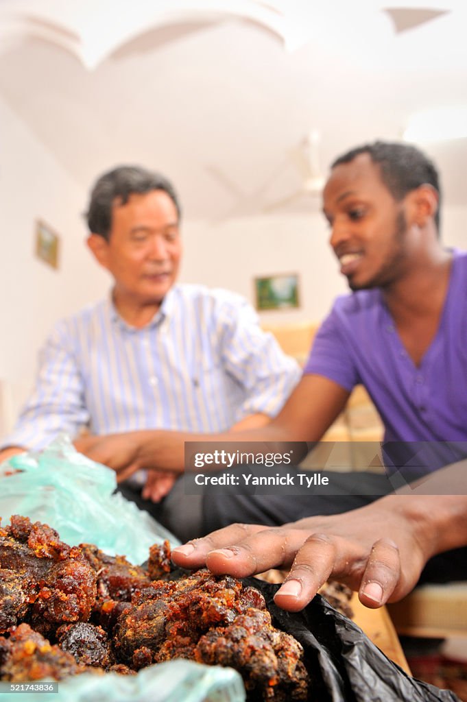 A Somali and a Chinese man bargain about a bag of myrrh resin in Bosaso, Puntland.