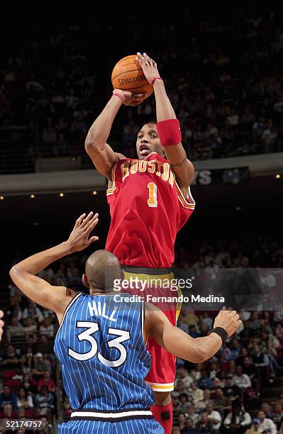 Tracy McGrady of the Houston Rockets shoots over Grant Hill of the Orlando Magic during the game at TD Waterhouse Centre on January 20, 2005 in...
