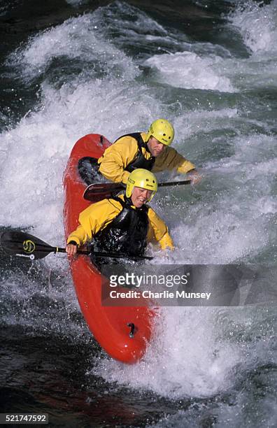 male and female kayakers surf a wave on the south fork of the payette river in idaho in a topduo kayak. ie 2 person kayak (k2 boat) mr: j1-wink jones, m4-kari miller - payette river stockfoto's en -beelden