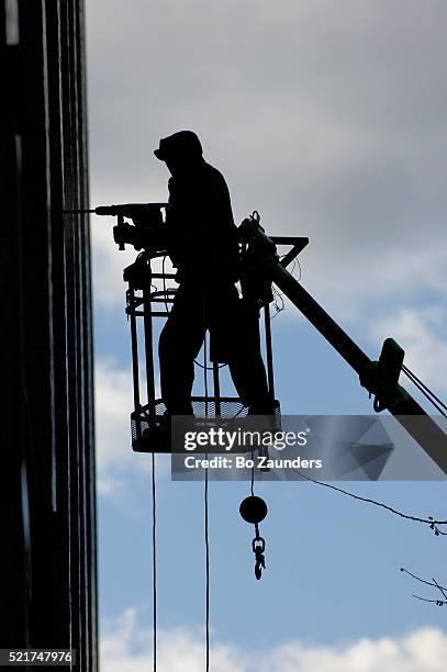 riveter on cherry picker - hebebühne stock-fotos und bilder