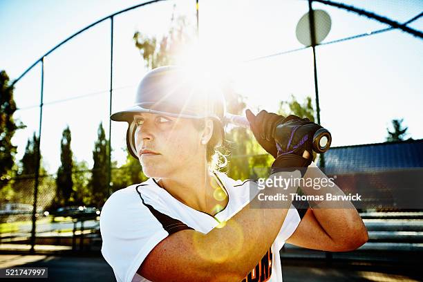 female softball player at bat at home plate - softball stockfoto's en -beelden