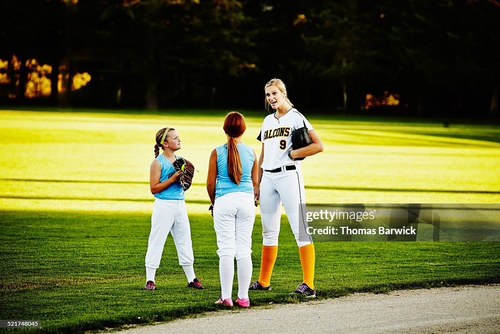 Adult softball player talking with younger players