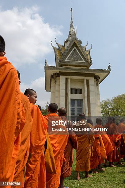 Cambodian monks line up in front of a stupa at the Choeung Ek killing fields memorial in Phnom Penh on April 17, 2016. Cambodian opposition officials...